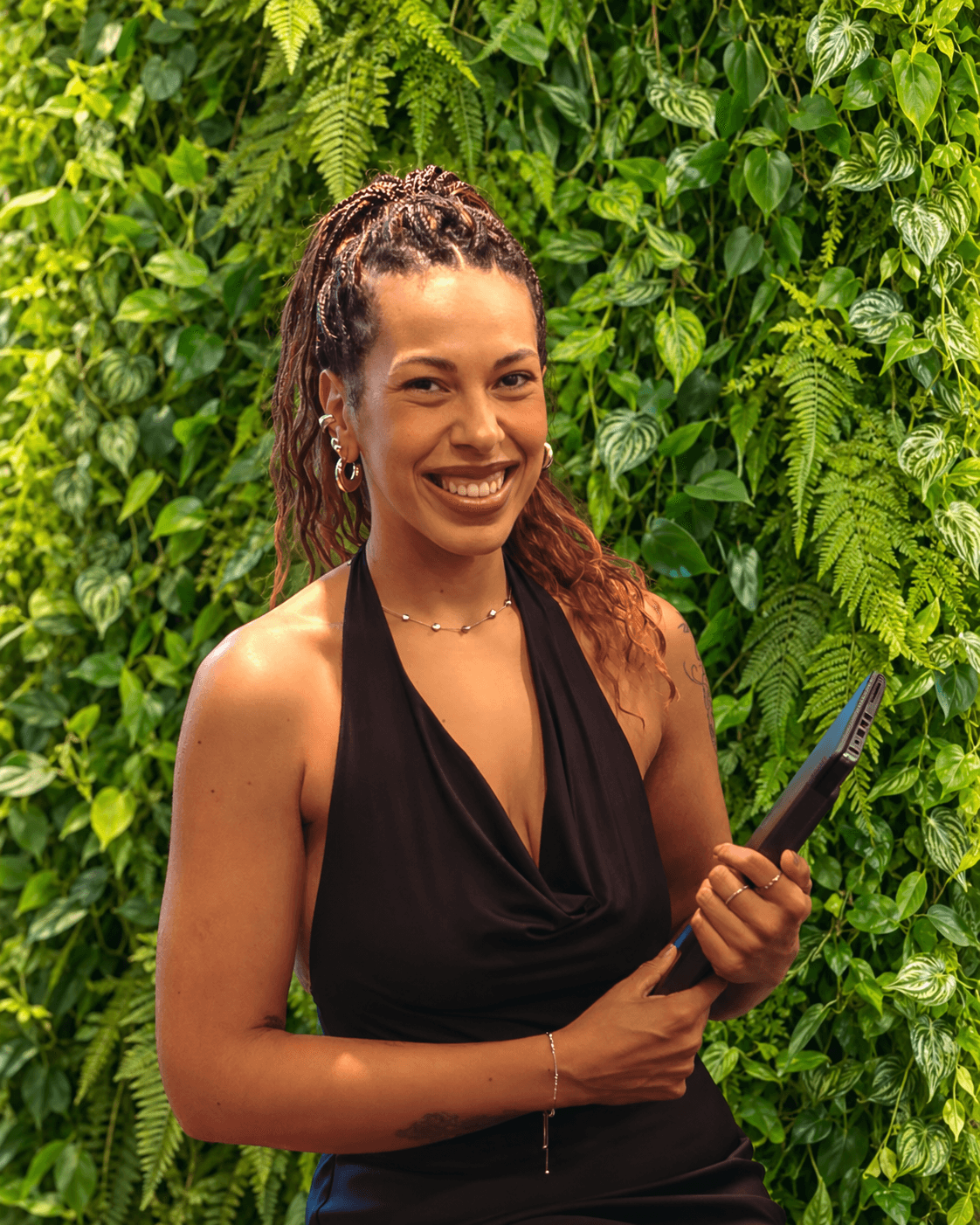 Aline Santos, da área de Compras da Studio Side, diante de um jardim vertical